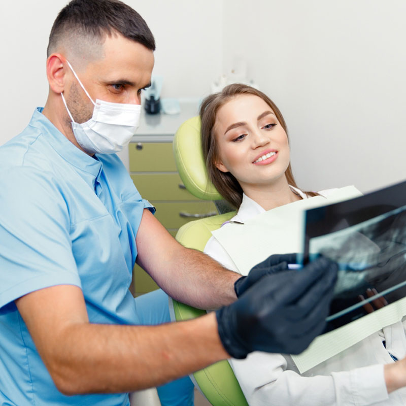 Dentist explaining an X-ray to a relaxed patient before an extraction